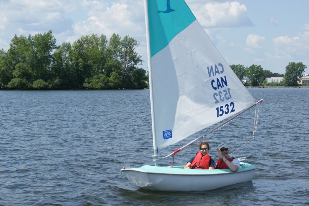 Two people sailing a Hansa adaptive sailboat
