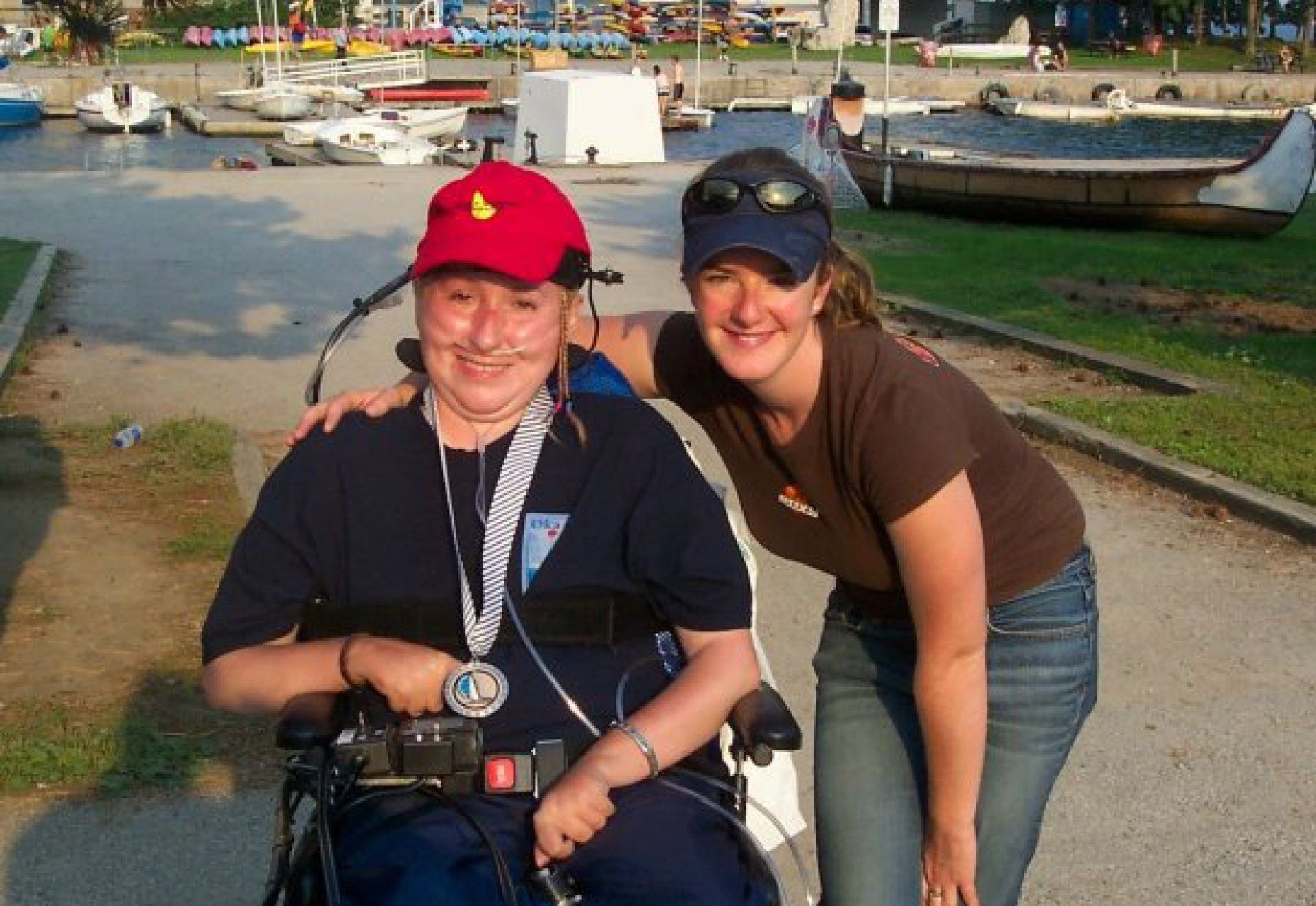 Jenny Davey standing next to Sylvie Séguin in wheelchair. Marina in background