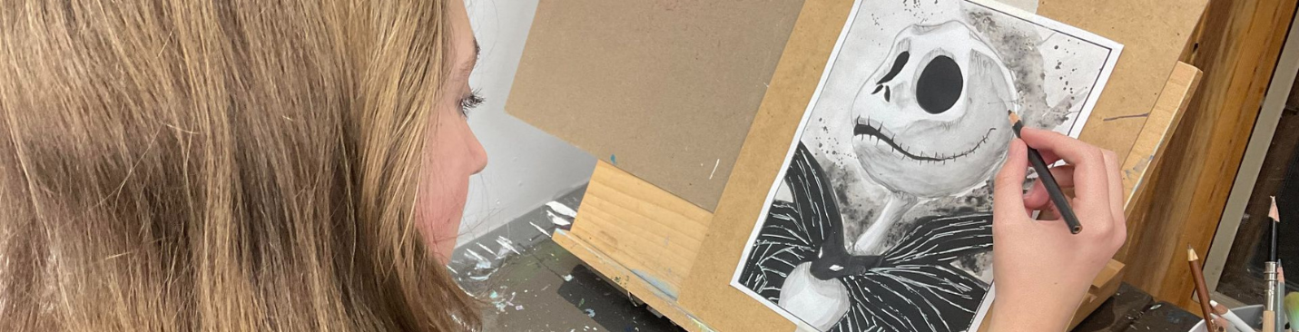 Teen student painting a winter scene at an easel in the Bedford art studio