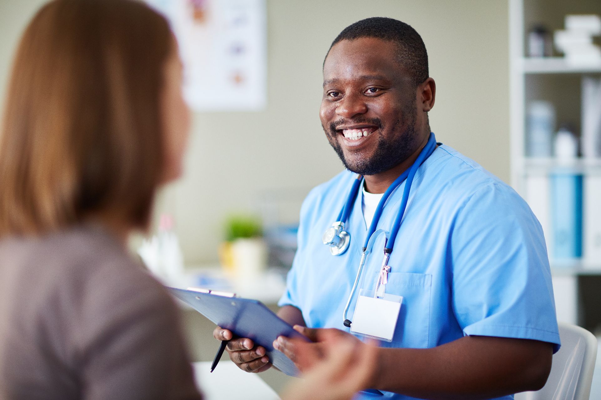 Banner image of man in scrubs smiling at patient